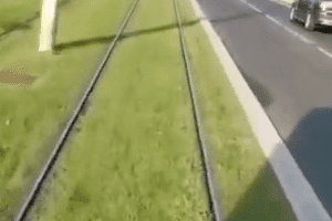 Un type à vélo s'énerve contre le tram qui le suit.