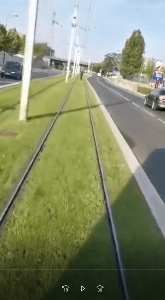 Un type à vélo s'énerve contre le tram qui le suit.